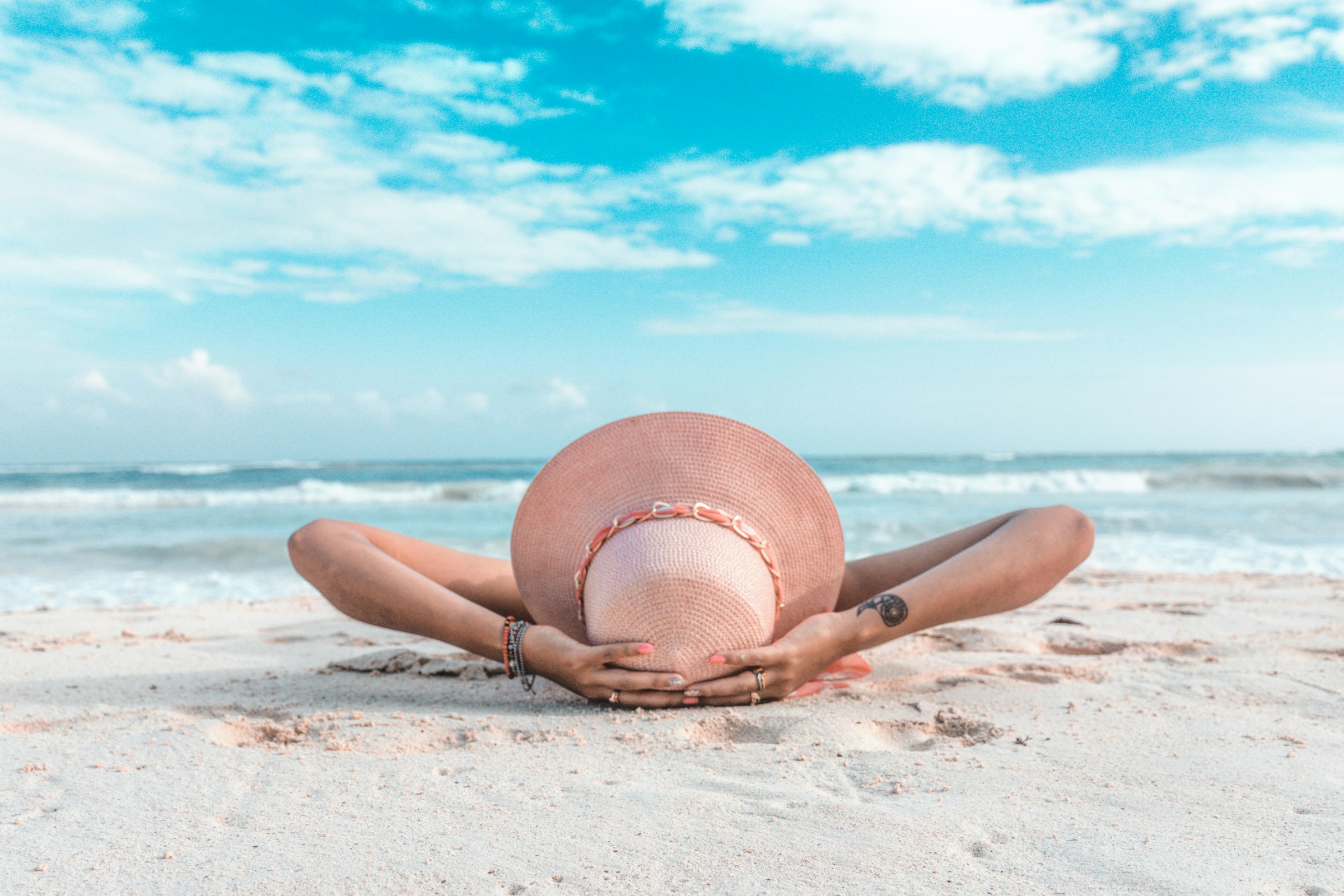 Donna al sole in spiaggia, esposizione solare e rischio di scottatura