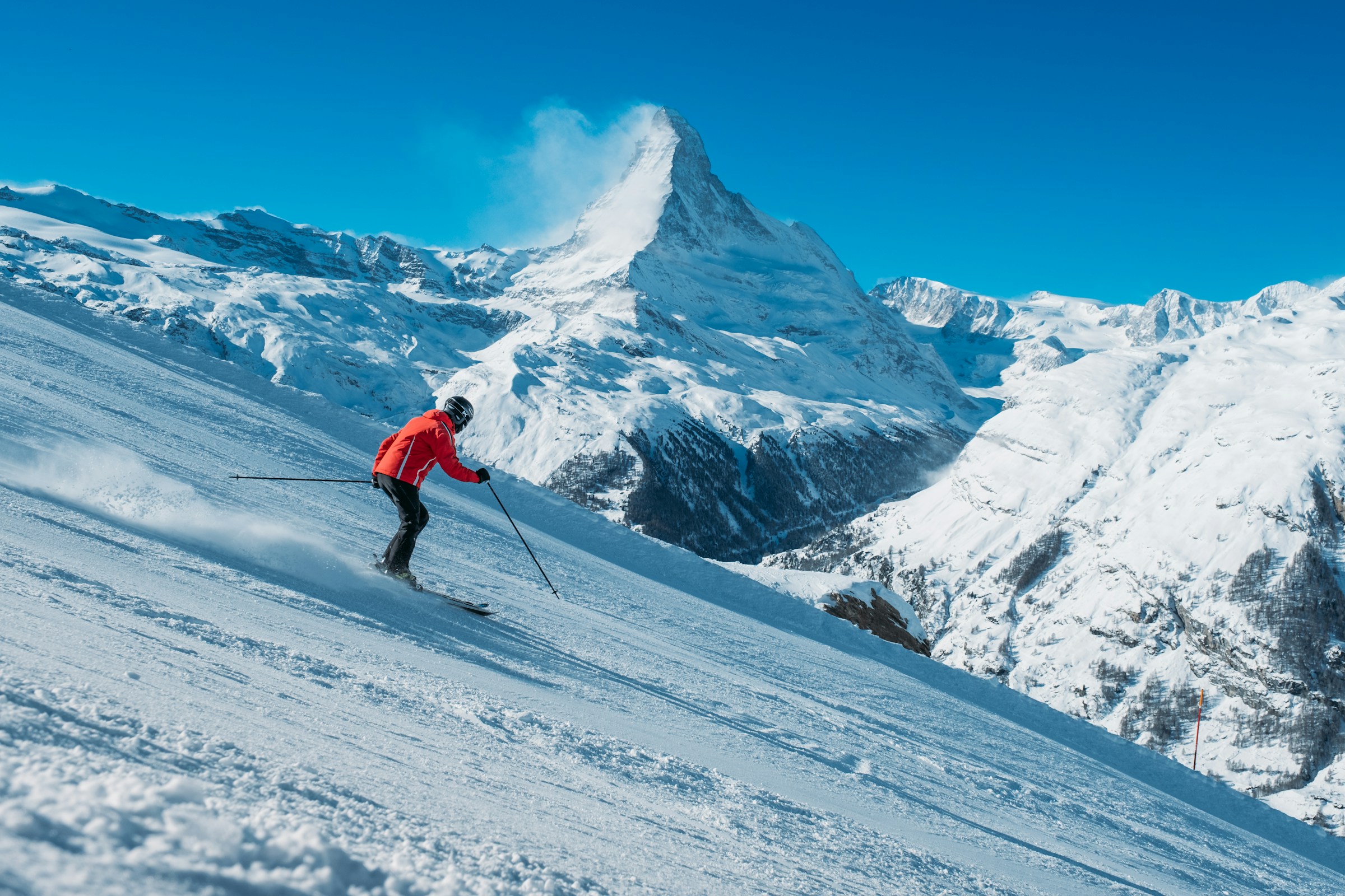 Sciatore in discesa su pista innevata durante una settimana bianca in montagna