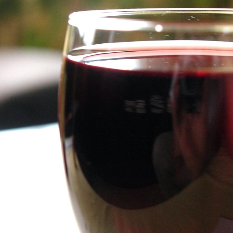 Bicchiere di vino rosso in controluce durante una degustazione professionale