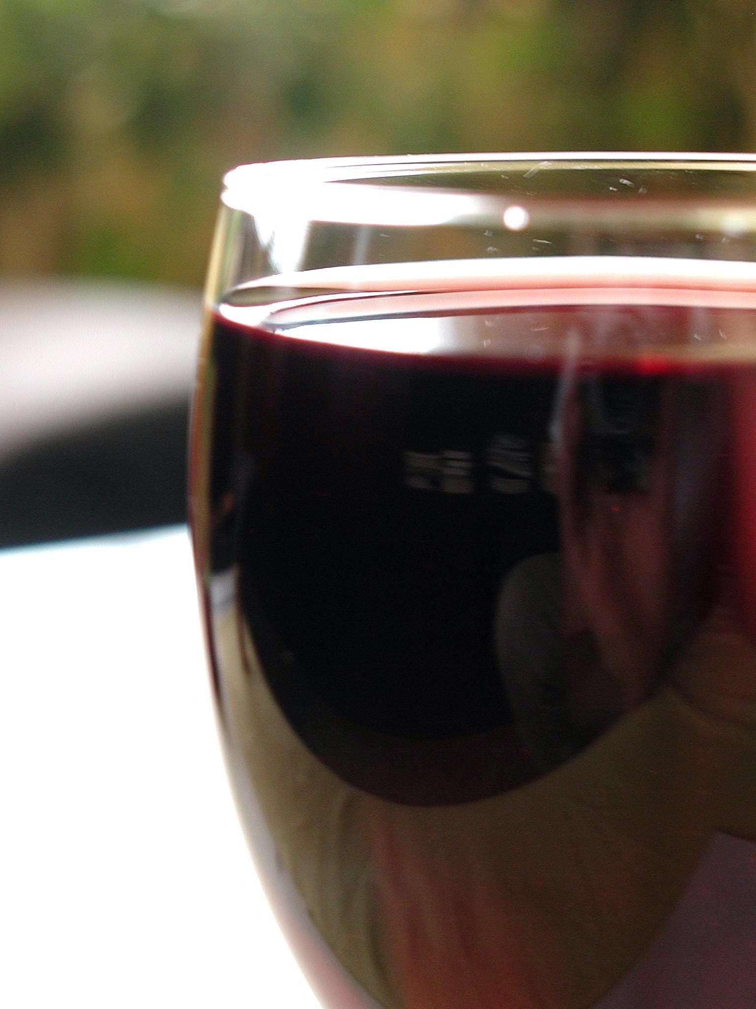 Bicchiere di vino rosso in controluce durante una degustazione professionale