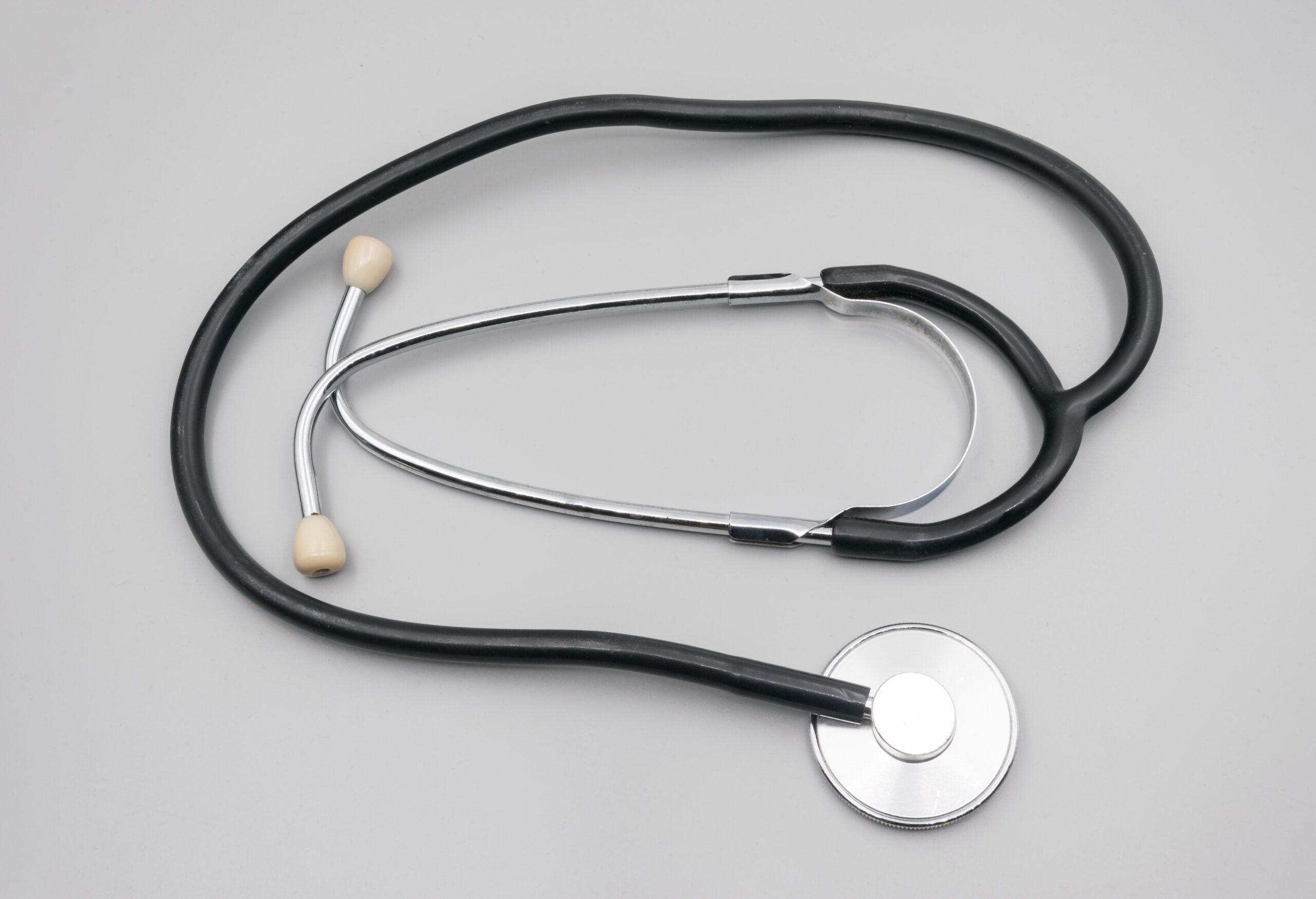 Stetoscopio su sfondo neutro, simbolo della visita medica quotidiana