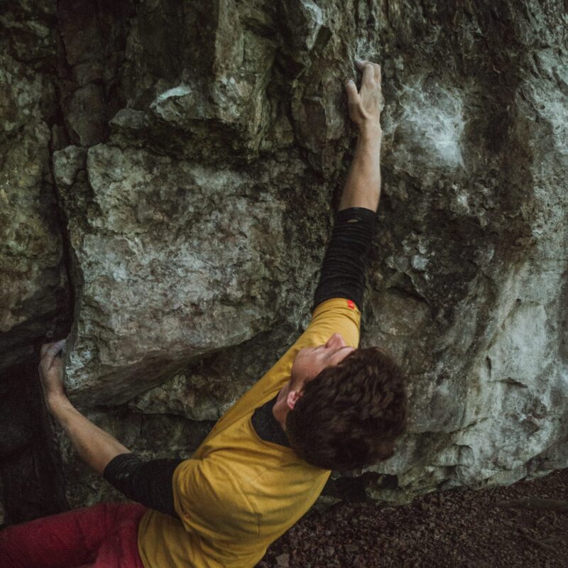 Uomo che si arrampica su una parete rocciosa, energia e vitalità maschile