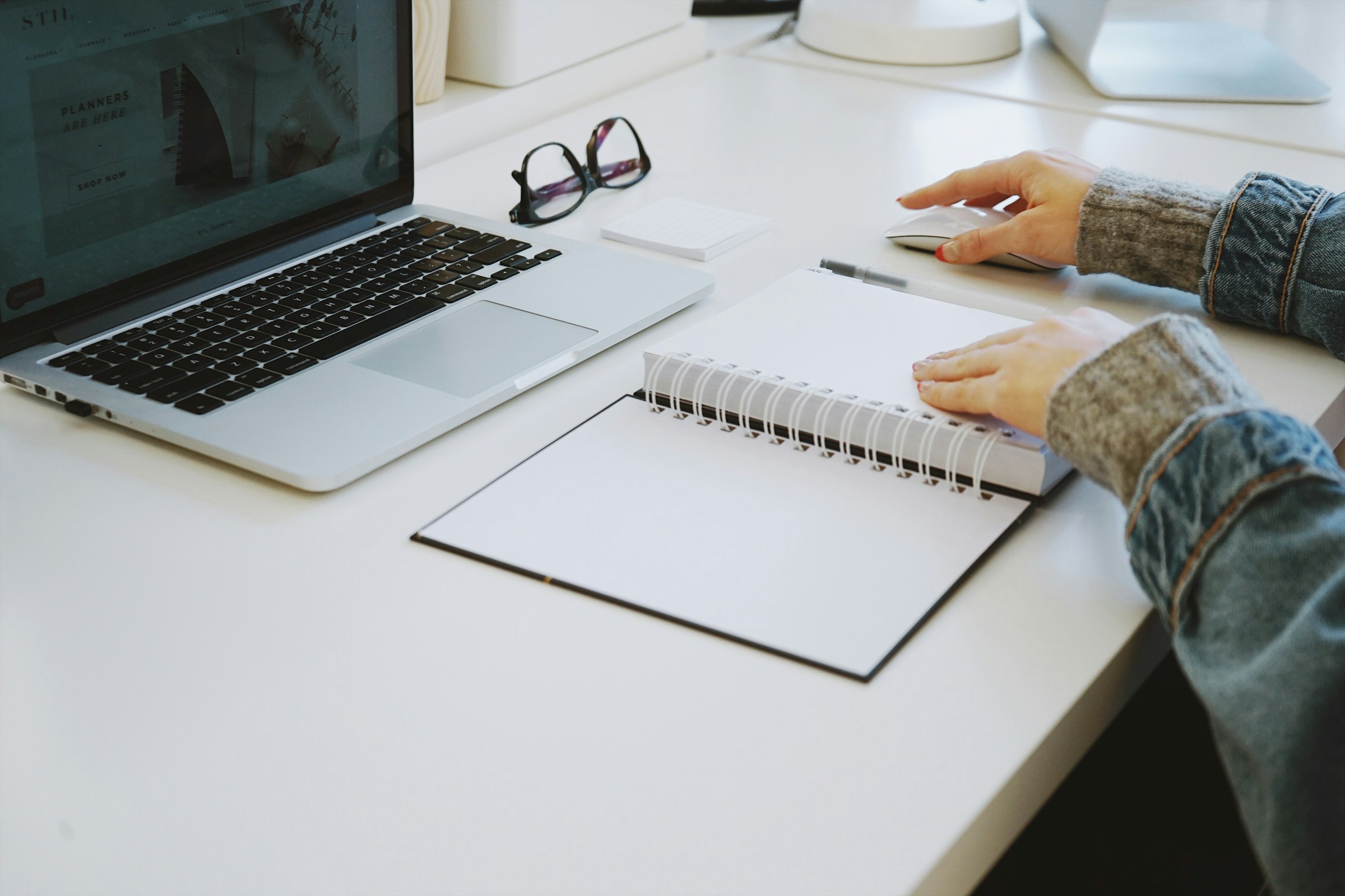 Persona che lavora concentrata a una scrivania con laptop e taccuino