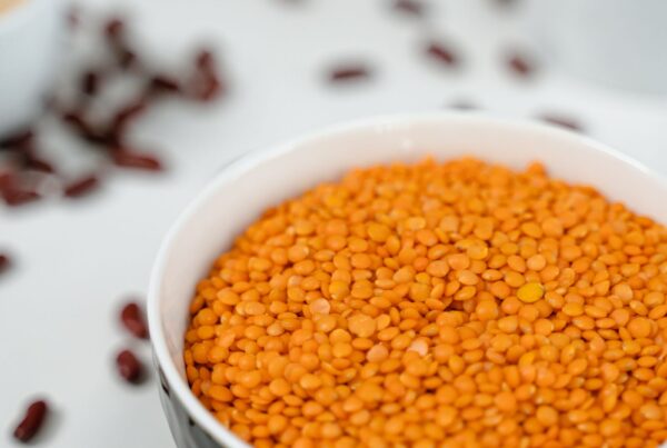 Lenticchie rosse crude in una ciotola, alimento ricco di acido fitico