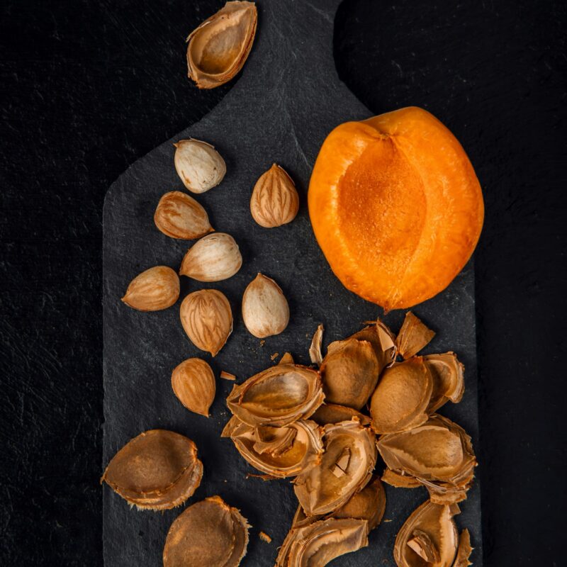 Albicocche aperte con i noccioli, da cui storicamente si estraeva il composto chiamato acido pangamico