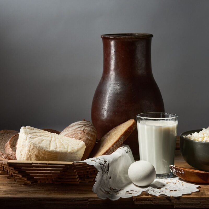 Natura morta rustica con pane, formaggio, latte e uova, alimenti fonte di calcio