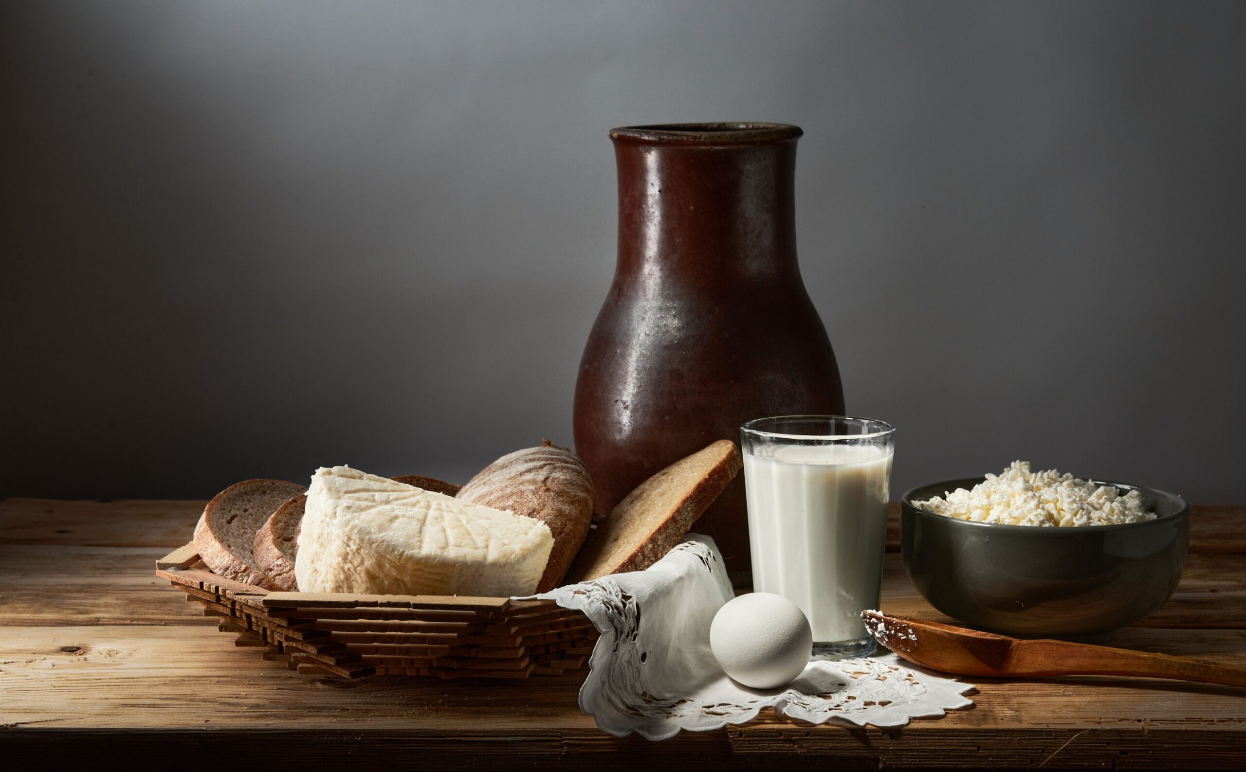 Natura morta rustica con pane, formaggio, latte e uova, alimenti fonte di calcio