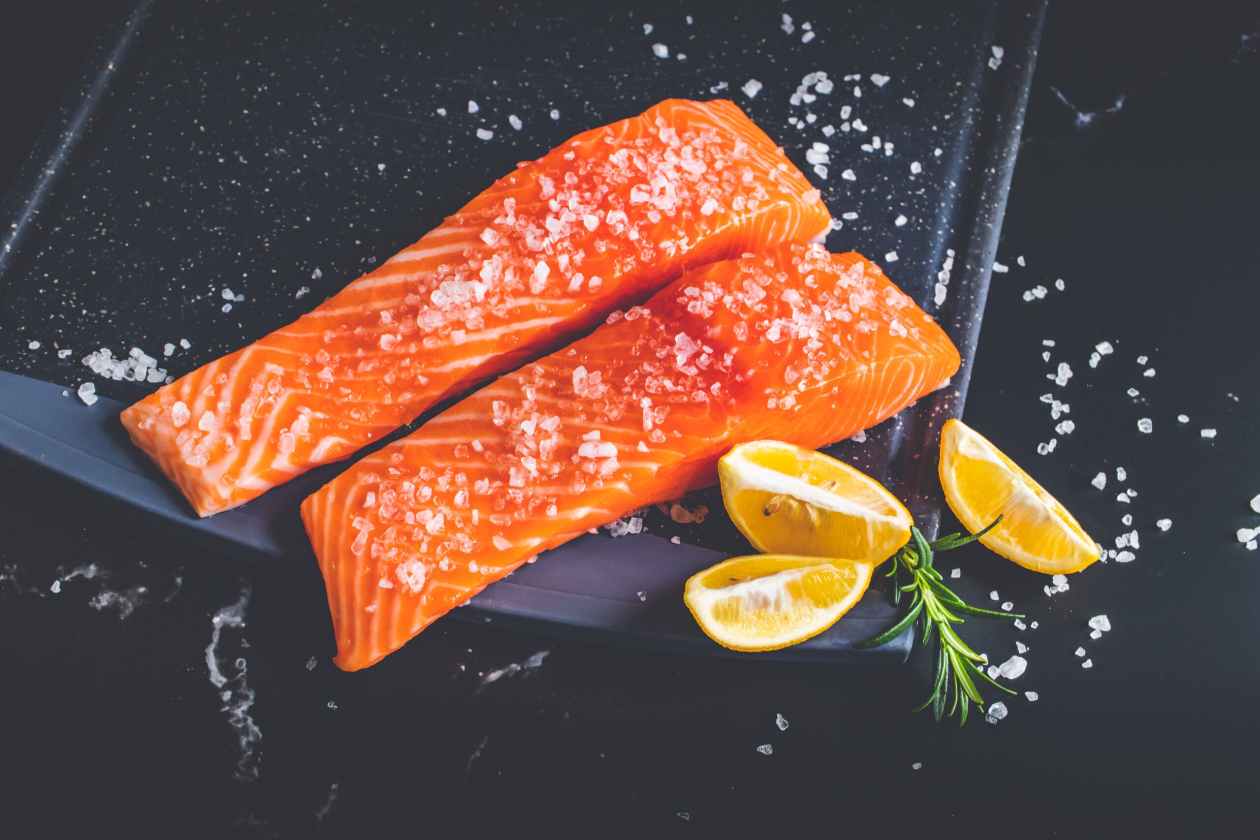 Filetti di salmone fresco con sale e limone, alimento fonte di vitamina B12 e cobalto