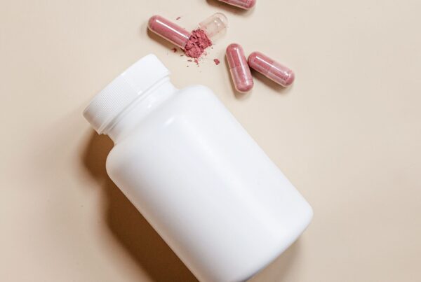 Capsule di integratore accanto alla confezione, lettura dell'etichetta nutrizionale