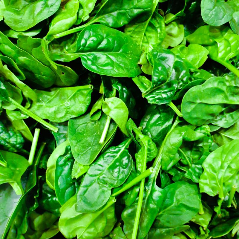 Foglie verdi fresche ricche di folati, correlate al ruolo del PABA nella sintesi dell'acido folico nei batteri