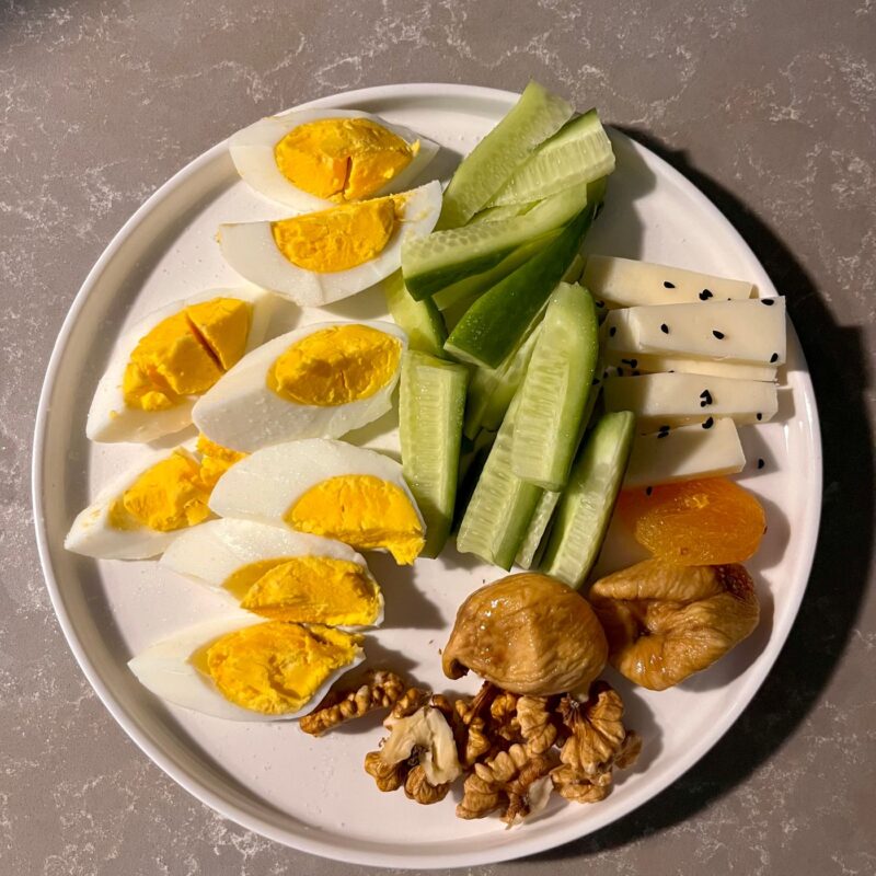 Piatto con uova sode, formaggio, noci e verdure, illustrazione delle fonti alimentari di fosforo