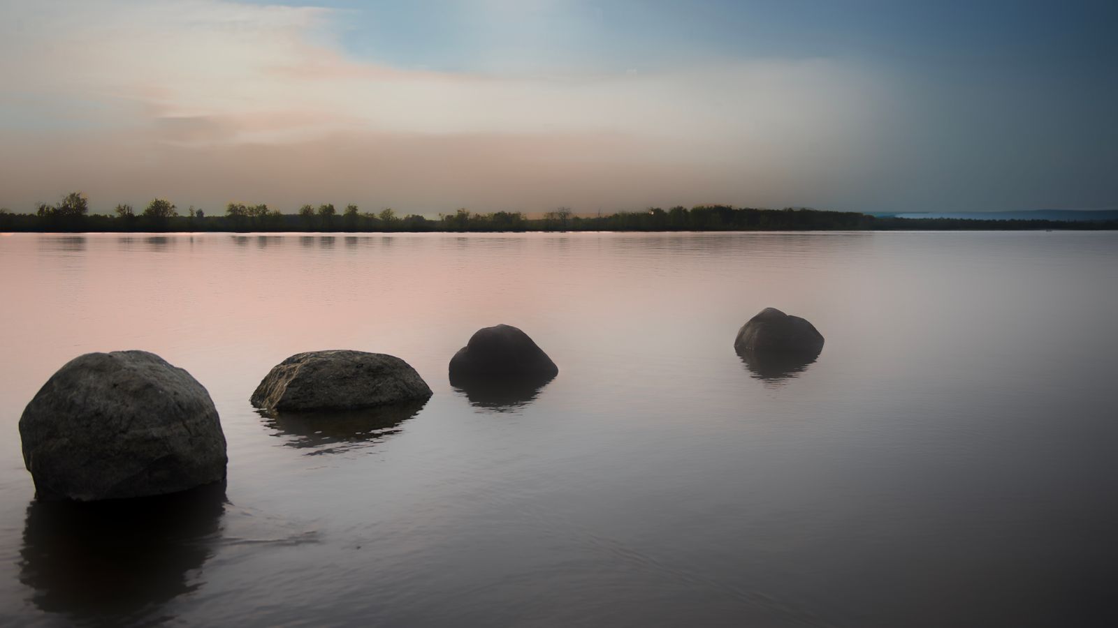 Paesaggio lacustre sereno al tramonto, simbolo di relax e serenità serale