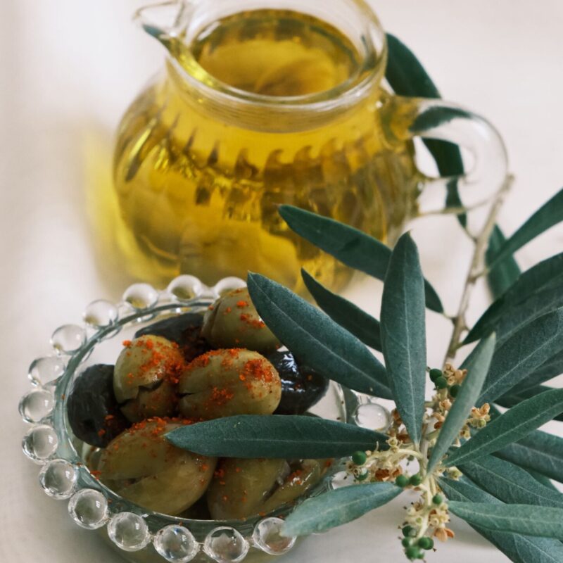 Olive verdi fresche e olio extravergine di oliva in un barattolo di vetro