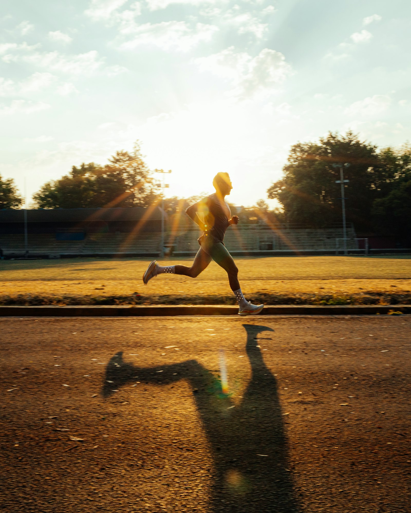 Corridore che si allena su una pista al tramonto, metabolismo energetico e L-carnitina