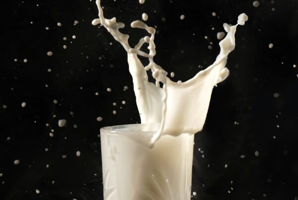 Latte versato in un bicchiere, fonte di sfingomielina e fosfolipidi del latte