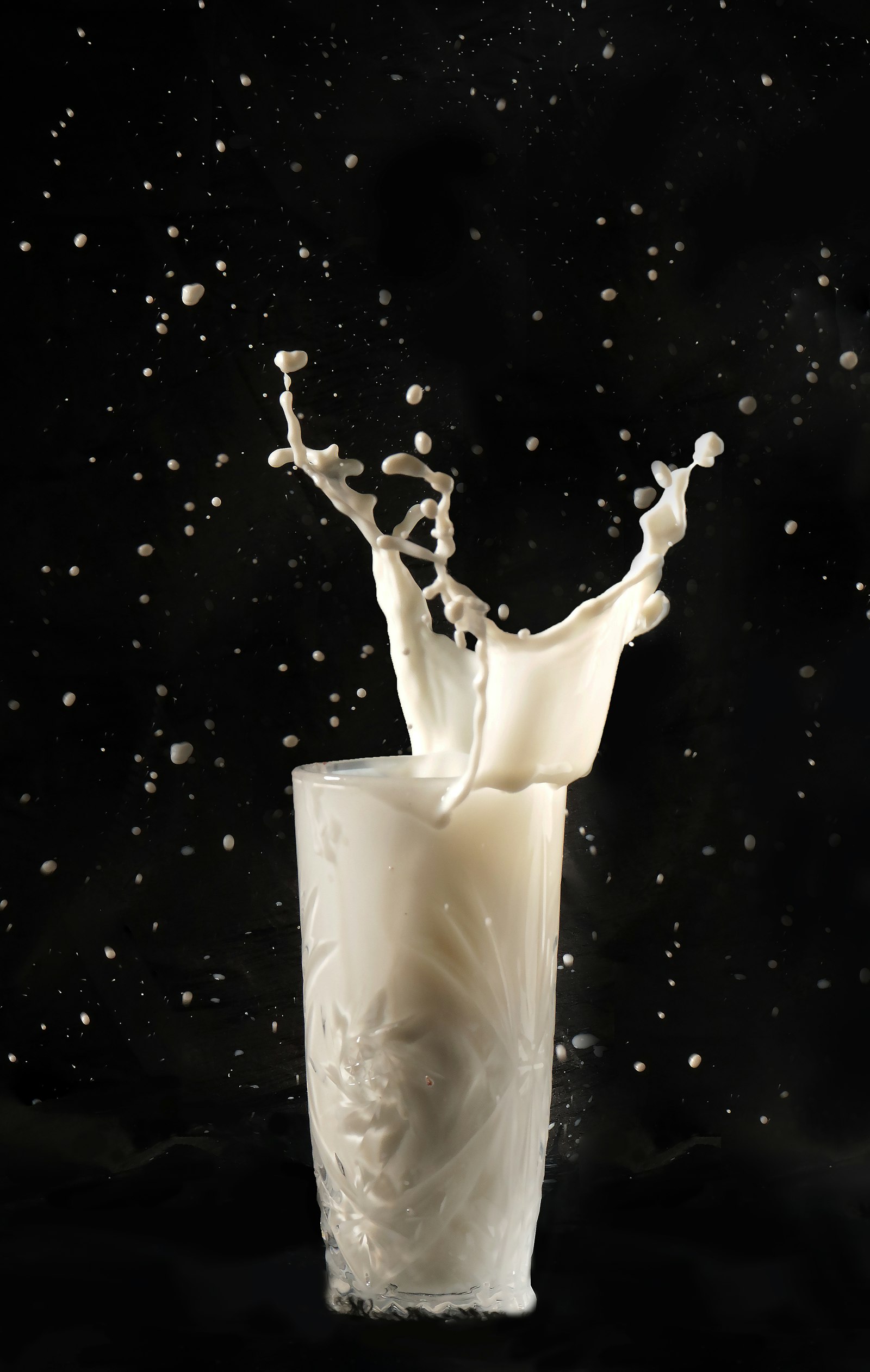 Latte versato in un bicchiere, fonte di sfingomielina e fosfolipidi del latte