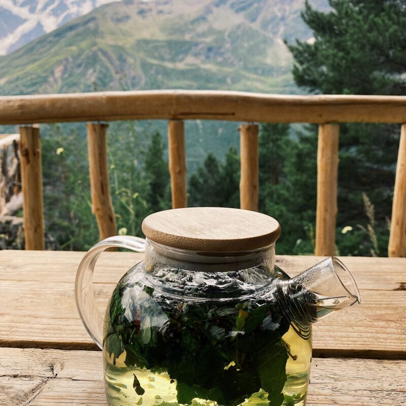 Tisana di erbe officinali in teiera di vetro, tradizione fitoterapica come la rodiola rosea