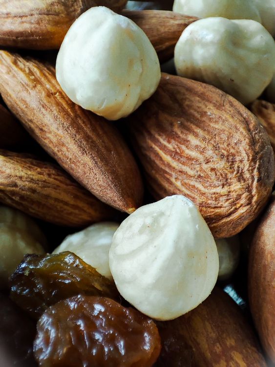 Primo piano di frutta secca mista (mandorle, nocciole) e uvetta, alimenti che possono contribuire all'apporto di selenio