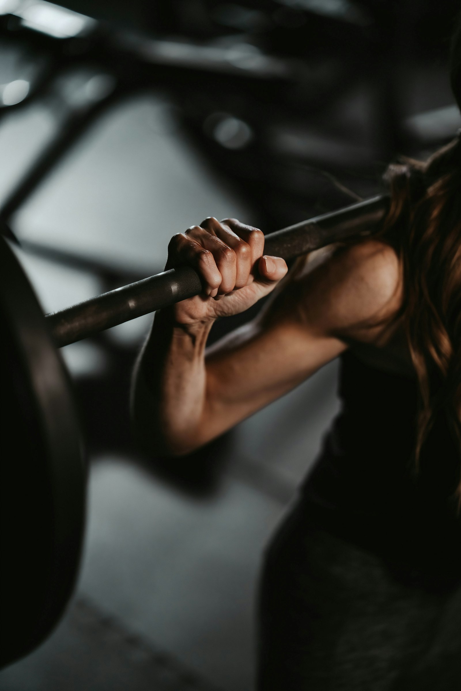 Atleta che solleva un bilanciere in palestra, allenamento di forza con integrazione di taurina e beta-alanina