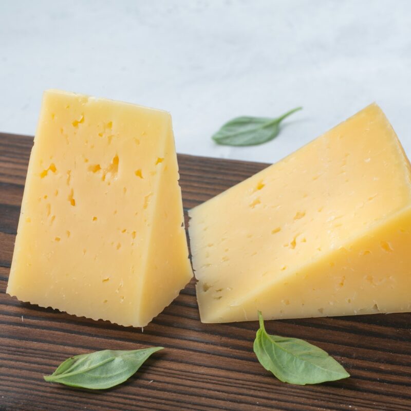 Formaggio stagionato a pezzi su tagliere di legno, alimento il cui nome ha dato origine alla parola tirosina