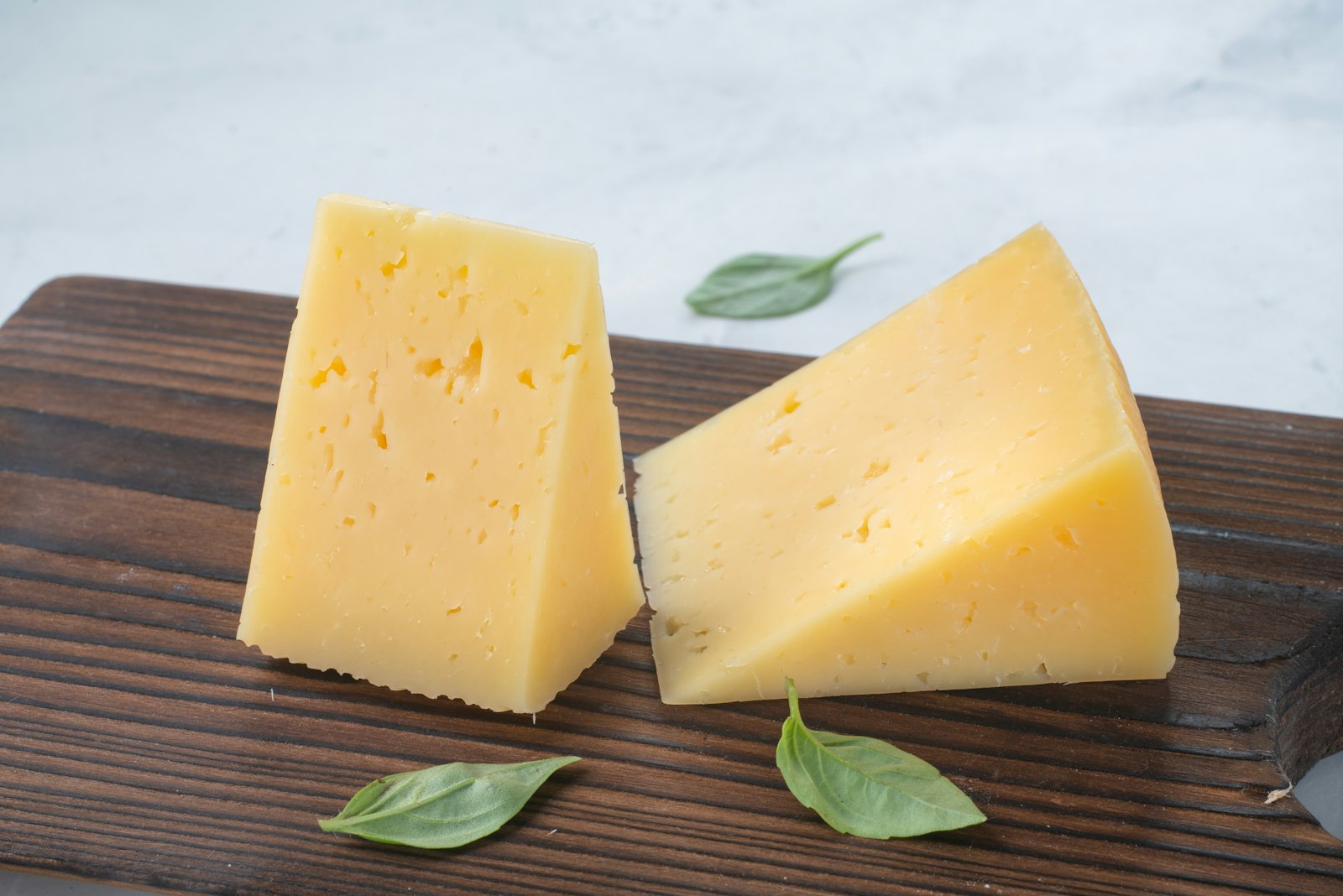 Formaggio stagionato a pezzi su tagliere di legno, alimento il cui nome ha dato origine alla parola tirosina