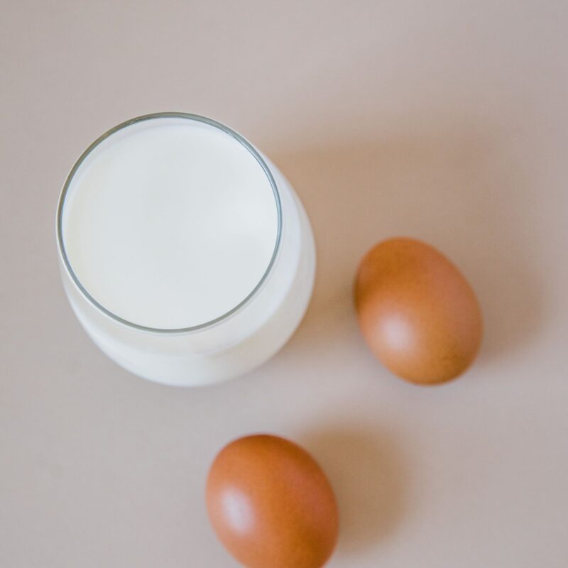 Bicchiere di latte e uova fresche, fonti alimentari di vitamina B2 (riboflavina)
