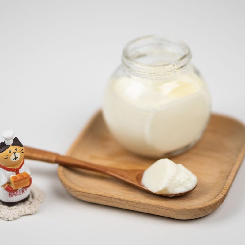 Vasetto di yogurt con cucchiaio di legno, fonte naturale di fermenti lattici vivi