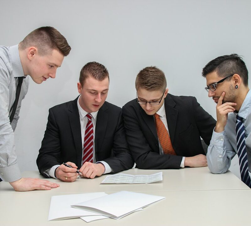Professionisti che revisionano insieme documenti e responsabilità operative di progetto