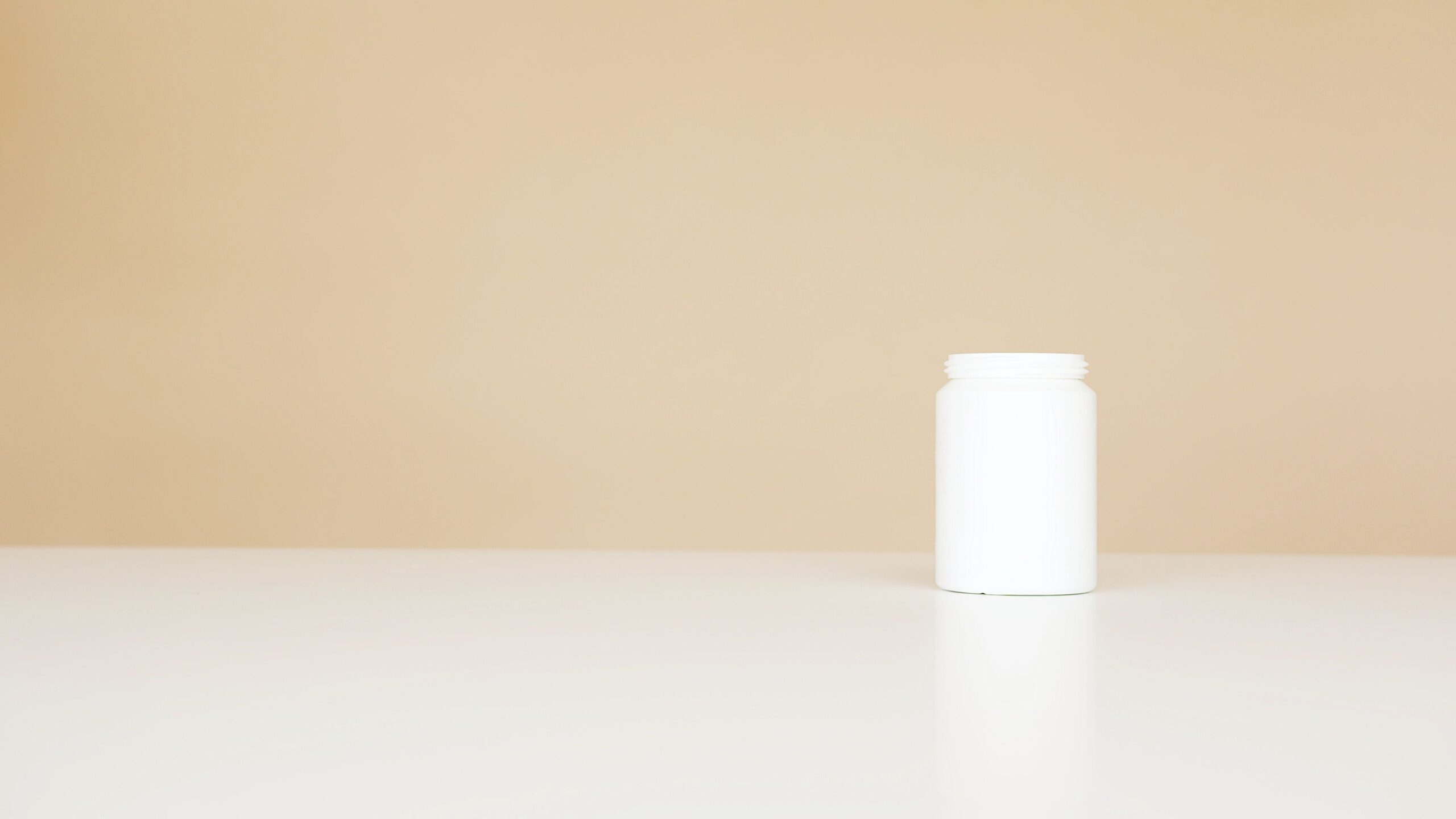 Flacone bianco neutro di integratore su fondo beige, immagine illustrativa del tempo di utilizzo