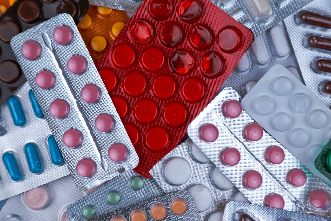 Compresse di diversi colori in confezioni farmaceutiche, immagine illustrativa delle segnalazioni di sospetti effetti indesiderati