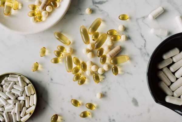 Assortimento di compresse e capsule di forme e dimensioni diverse su un piano chiaro