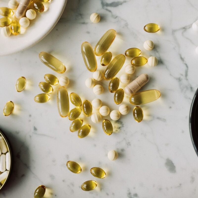 Assortimento di compresse e capsule di forme e dimensioni diverse su un piano chiaro