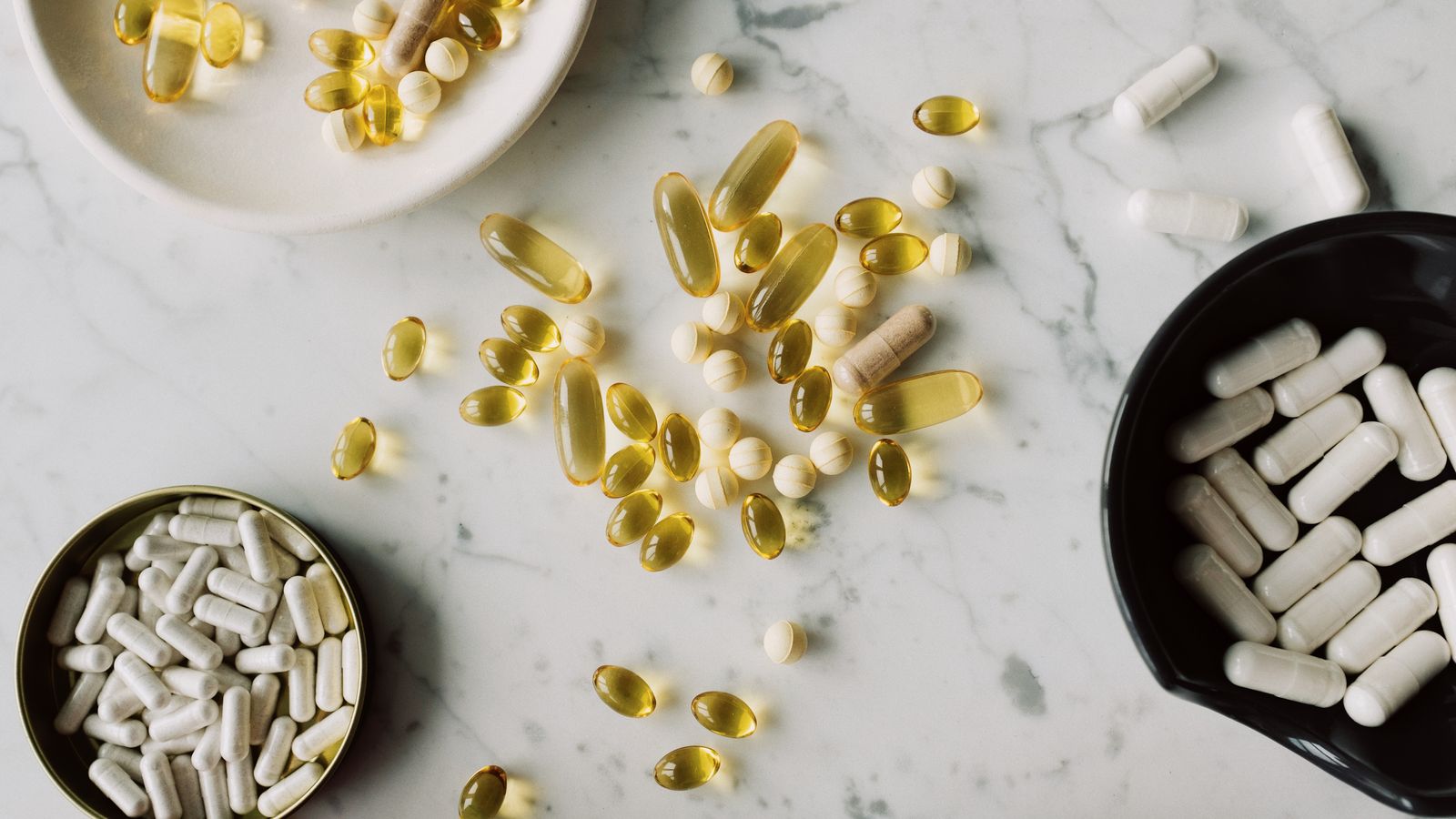 Assortimento di compresse e capsule di forme e dimensioni diverse su un piano chiaro