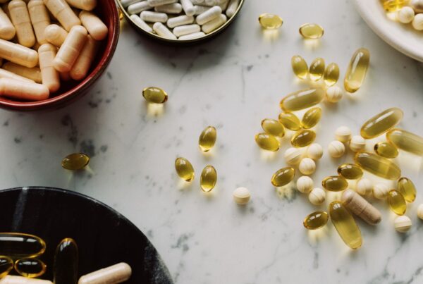 Capsule e integratori diversi disposti su un piano in marmo, immagine illustrativa di formule con più ingredienti