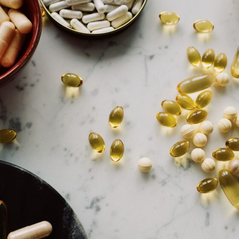 Capsule e integratori diversi disposti su un piano in marmo, immagine illustrativa di formule con più ingredienti